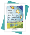 A greeting card with a whimsical sky illustration and the quote, 'There is no one quite like you, and I mean that in a good way.' The card is shown with a teal envelope behind it on a white background.