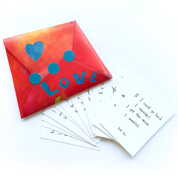 Colorful envelope with 'LOVE' and hearts, accompanied by handwritten cards on a white background